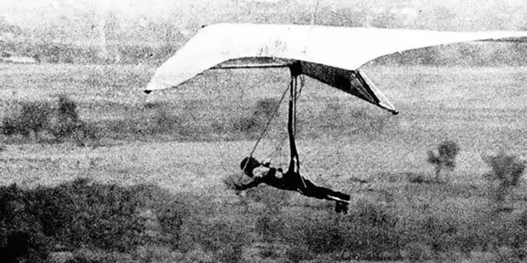 Fotografía antigua de un hombre volando en un ala delta.