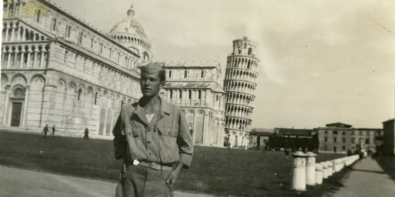 Fotografía de un soldado en Italia frente a la torre de Pisa.